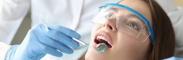 Dentysta bada jamy ustnej kobiety w biurze zbliżenie — Zdjęcie stockowe