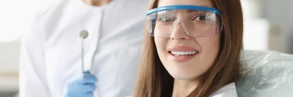 Портрет улыбающейся женщины в очках на приеме у стоматолога — стоковое фото