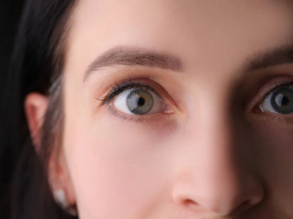 Closeup of female eyes with permanent eyebrow makeup and false eyelashes — Stock Photo, Image