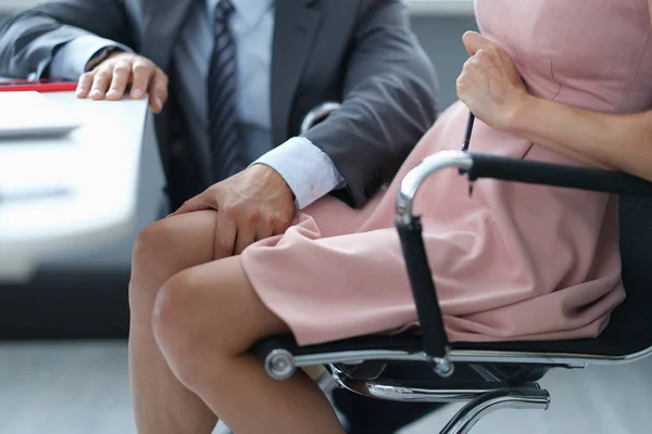 Uomo in tuta accarezzando ginocchio della segretaria donna al lavoro primo piano — Foto Stock