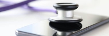 Cep telefonunun kapalı ekranında duran tıbbi enstrüman steteskopu