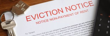 Metal house keys and mobile phone lying on eviction notice closeup clipart