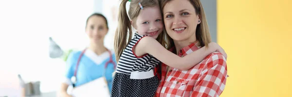 Moeder houden klein meisje in haar armen bij arts afspraak — Stockfoto