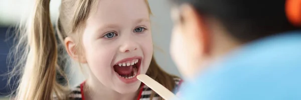 Otorhinolaryngologist doctor examining sore throat little girl in clinic — Stock Photo, Image