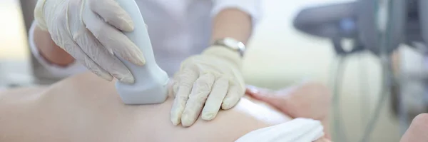 Médecin tenant une sonde échographique sur le sein d'une patiente en clinique en gros plan — Photo