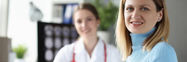 Mujer joven sentada en la mesa en la cita con el médico — Foto de Stock