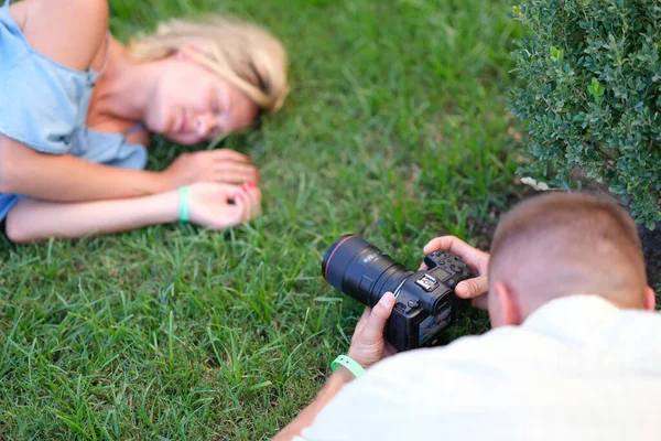 Hombre fotografiando mujer joven durmiendo en la hierba — Foto de Stock