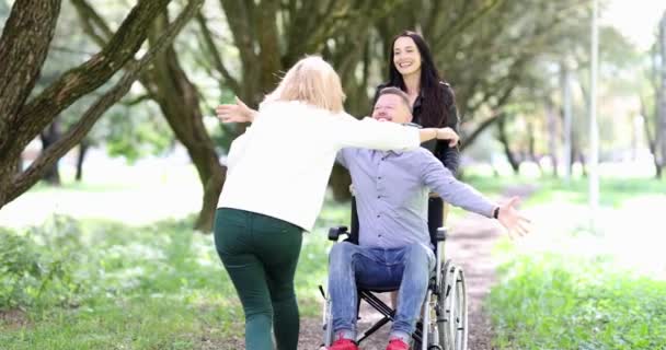公园4k电影中坐在轮椅上拥抱女人的年轻残疾男子 — 图库视频影像