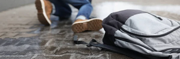 Uomo con zaino abbattimento sul marciapiede scivoloso in primo piano invernale — Foto Stock
