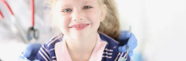 Niña sonriente sentada en la cita con el dentista — Foto de Stock