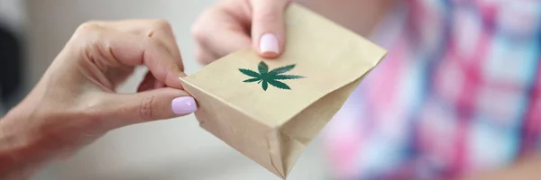 Kvinna ger papperspåse marijuana närbild — Stockfoto