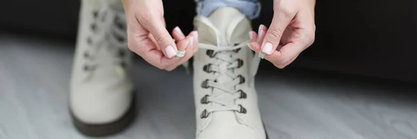 女人把鞋带系在白色保暖鞋的特写上 — 图库照片
