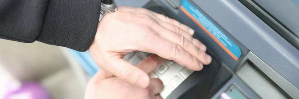 Mężczyzna wprowadza kod na klawiaturze bankomatu i zamyka go ręką — Zdjęcie stockowe