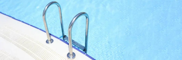 Gros plan des escaliers menant à la piscine avec eau bleue — Photo