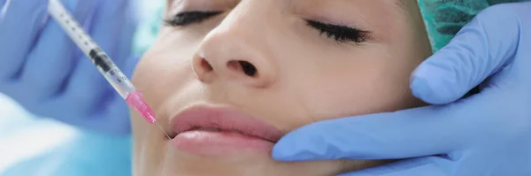 Lekarz kosmetolog robi zastrzyk młodej kobiecie w klinice — Zdjęcie stockowe