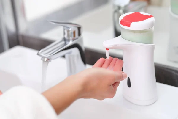 Vrouw het oppakken van vloeibare zeep uit de hand dispenser in badkamer closeup — Stockfoto