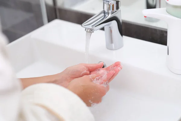 Donna che si lava le mani sotto l'acqua dal rubinetto in bagno primo piano — Foto Stock