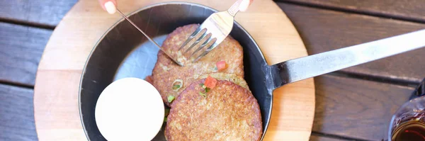 Donna che mangia frittelle di patate con salsa di panna acida in primo piano caffè — Foto Stock