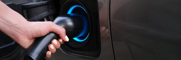 Mujer cargando coche usando enchufe eléctrico primer plano — Foto de Stock