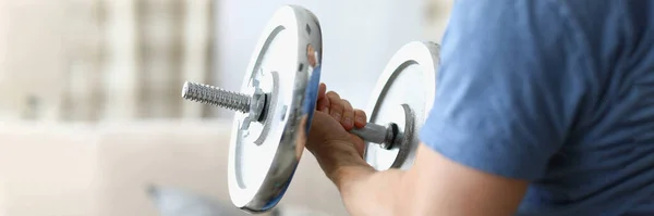 Man hand lifts heavy dumbbell while swinging biceps — Stock Photo, Image