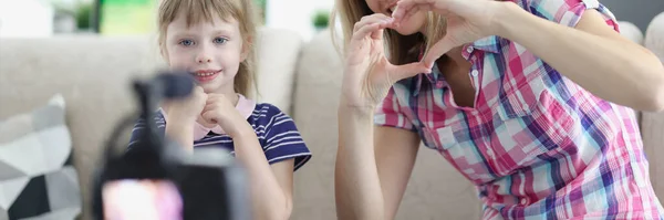 Maman et petite fille montrent le cœur avec leurs mains à la caméra — Photo