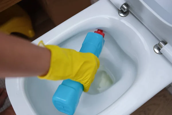 Mulher mão derrama agente de limpeza em vaso sanitário closeup — Fotografia de Stock