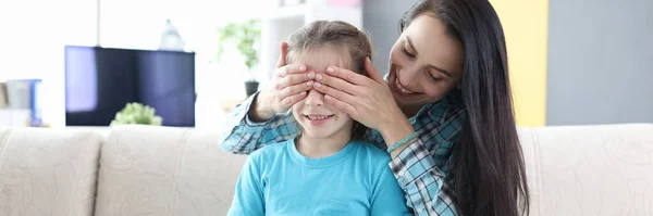 Joven madre cierra los ojos de su hija y le da su regalo —  Fotos de Stock