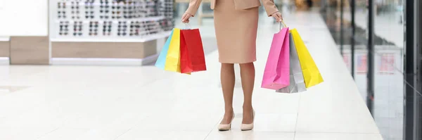 Mulher alegre fica no shopping com sacos de compras de papel — Fotografia de Stock