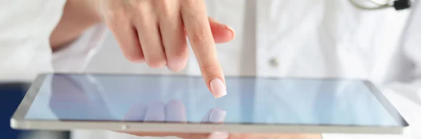 Doctor poniendo su dedo en la pantalla táctil de la tableta digital en primer plano clínica — Foto de Stock