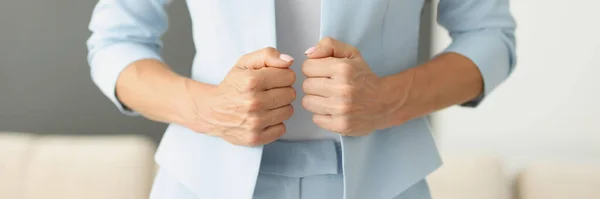Woman in blue suit holding edges of her jacket with her hands closeup — Stock Photo, Image