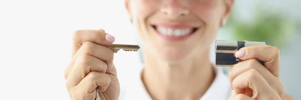 Mulher sorridente em tampa vermelha segurando chave e fechadura closeup — Fotografia de Stock