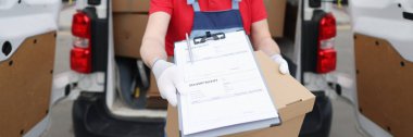 Courier driver in medical protective mask and gloves holds out documents with delivery receipt clipart