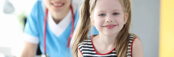 Porträt eines glücklichen kleinen Mädchens, das nach guter Beratung mit dem Kinderarzt vor der Kamera posiert — Stockfoto