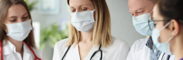 Team van artsen met medisch beschermend masker dat de resultaten van medisch onderzoek onderzoekt — Stockfoto