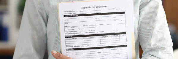 Businesswoman holds application form employment document in hands