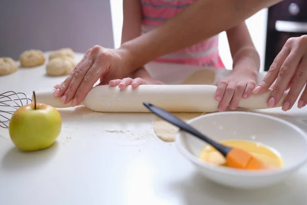 Madre e hija desplegando masa de harina en primer plano de la mesa — Foto de Stock