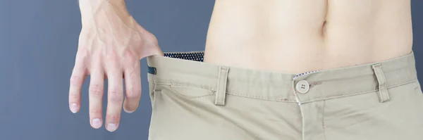 Emagrecimento muscular homem no calças que muito grande closeup — Fotografia de Stock