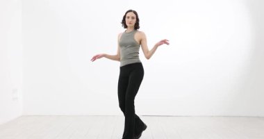 Şık giyinmiş genç bir kadın zarif bir şekilde geniş stüdyoda dolaşıyor. Kadın dansçının vücudu, sessiz bir melodiyle ritim içinde akıyor. Yavaş çekim