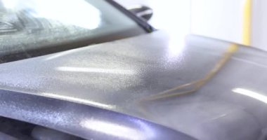 Profesyonel temizlik istasyonunda su spreyi ile araba yıkamak. Garaj oto yıkama makinesinde sıvı ile kaputun kirini temizliyorum. Araç bakımı