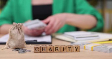 Sıcak ve cezbedici bir çalışma alanında bağış organize eden bir insan. Elleri para ve banknotları saymakla meşgul, yanında da sevimli bir tavşan var. Her katkı daha parlak bir gelecek için önemlidir..