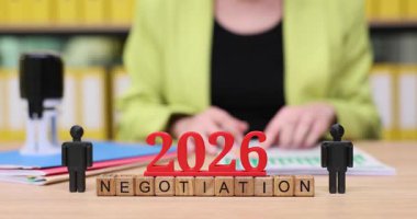 Canlı bir ofiste, bireyler 2026 yılında yapılacak müzakerelere ilişkin stratejiler hakkında tartışmalara giriyorlar. Renkli bloklar ve belgeler ilham verici bir atmosfer yaratıyor..