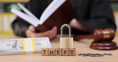 Hukuki sembollerle dolu bir mahkeme salonunda, yargıç belgeleri incelerken madeni paralar ve asma kilit, ilgi çekici bir görsel anlatımda hırsızlık ve adalet kavramlarını temsil eder..