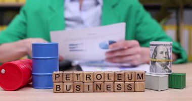 Çizelge ve raporlara odaklanan bir kişi, parlak bir ofis masasında petrol işiyle ilgili önemli verileri analiz eder. Renkli konteynırlar ve bloklar çalışma alanı atmosferini artırır.