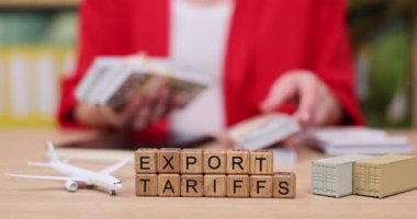 Parlak bir ofiste, insan ihracat vergilerini yazarken yanında yığınla para sayıyor. Görüşmede uluslararası ticaretteki gümrük vergilerinin önemi üzerinde duruldu.