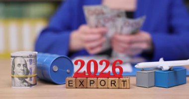 Bir kişi 2026 yılındaki ihracat projesine hazırlanırken nakit para sayıyor. Küresel ticaretin önemini vurgulayan uçak ve nakliye konteynırlarının modelleri.
