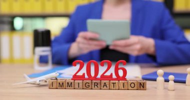 2026 göçmenlik ile ilgili önemli belgeler düzenleyen bir kadın. Evrak işlerini dikkatlice halleder ve ilerideki yolculuğuna her şeyin hazır olması için çeşitli aletler kullanır..