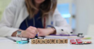 Kadın tıp uzmanı, masa başında kangrenle tahta bloklara ve su toplayan haplarla yazıyor. Doku çürümesiyle ilgili teşhis bağlamında