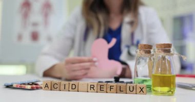 Tıbbi uzmanlar, masadaki asit reflüsünün yanında mide kesesinden kağıt kesiği tutuyorlar. Sindirim sorunlarıyla ilgili hasta eğitimine odaklanın