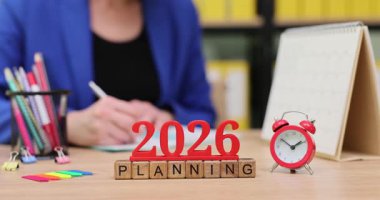 2026 yılı için ayrıntılı planlama işine odaklanmış bireyler. Düşünceleri düzenlemek ve hedefleri belirlemek için çeşitli renkli kırtasiyeler kullanılır. Atmosfer parlak ve ilham verici..