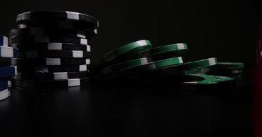 Masanın yüzeyine rengarenk kumarhane fişleri ve zarlar yerleştirilmiş. Poker çipleri ve kırmızı zarlar dağıtıcının bir sonraki hamlesini bekleyin